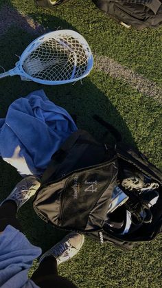 two tennis racquets are laying on the grass next to a bag and backpack