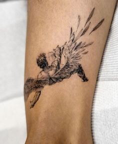 a woman's foot with an angel tattoo on the side of her leg,