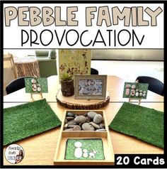 a table topped with rocks and grass covered in pictures next to a potted plant