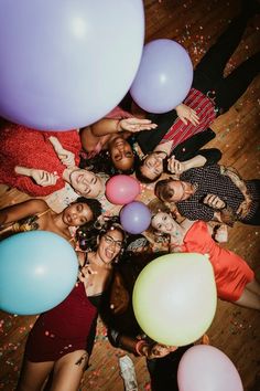 a group of people standing around each other with balloons