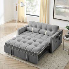 a living room scene with focus on the grey couch and white carpeted flooring