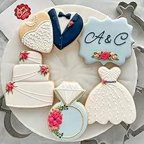 decorated cookies are arranged on a plate with the names of their wedding day and date