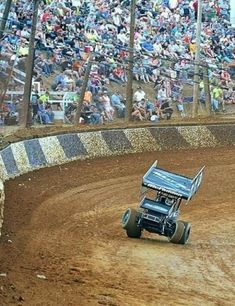 a man riding on the back of a dirt bike in front of a large crowd