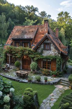 a house with lots of flowers growing on it's roof and windows in the front yard