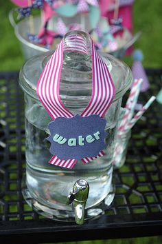 there is a glass with water in it and some straws on the table next to it