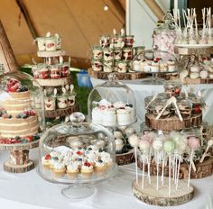 a table topped with lots of cakes and cupcakes