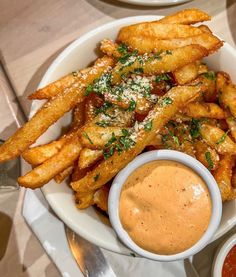 a white plate topped with french fries and dipping sauce