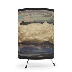 a lamp that is on top of a tripod with an image of mountains in the background