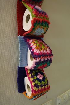 three rolls of toilet paper are hanging on the wall with crocheted designs and butterflies