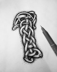 a drawing of a celtic knot on paper next to a pen and ink dot marker