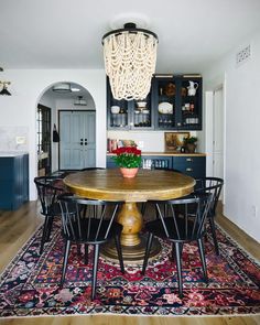 a dining room table with chairs and a rug on the floor in front of it