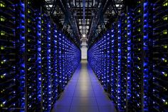 rows of blue and yellow computer servers in a data center, with lights on them