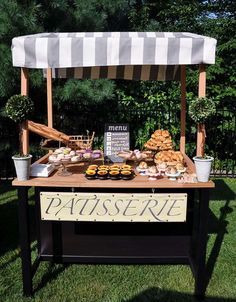 a table with food on it in the middle of some grass and trees behind it is a sign that says patissee