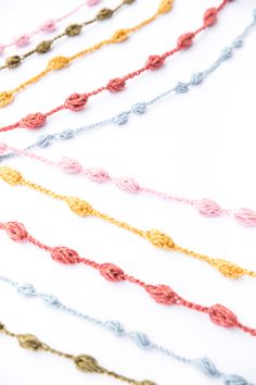 multicolored rope necklaces laid out on top of each other