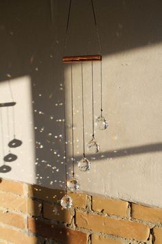 a wind chime hanging from the side of a brick wall