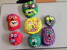 five brightly colored rocks with faces painted on them