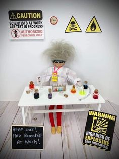 a doll sitting at a table with some stuff on it