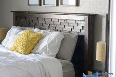 a bed with white sheets and yellow pillows on top of it next to two framed pictures