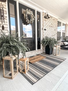 two planters on the front porch of a house with black and white striped rug