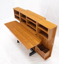 a wooden desk with drawers and shelves on it's sides, in front of a white background