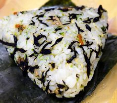 a close up of food on a plate with rice and other items in the background