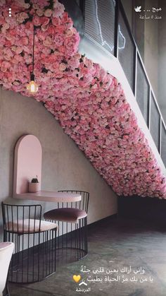 the interior of a restaurant with pink flowers hanging from the ceiling