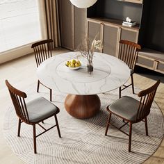 a white marble dining table with four chairs and a bowl of fruit on the top