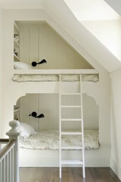 there is a bunk bed in the room with two ladders on top of it