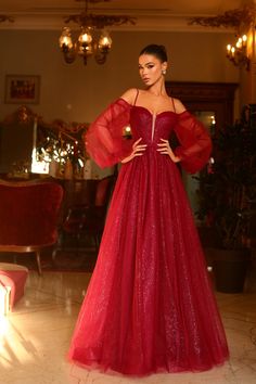 a woman in a red gown standing on the floor