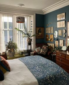 a bedroom with blue walls and pictures on the wall