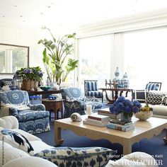 a living room filled with blue and white couches next to a table covered in flowers