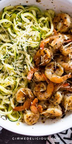 shrimp and zucchini pasta with pesto sauce in a white bowl on a patterned cloth