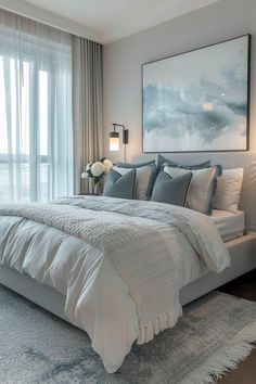 a large white bed sitting in a bedroom next to a window with curtains on it