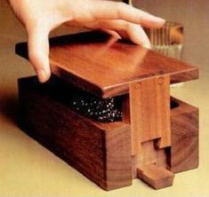 a hand reaching for something on top of a wooden box