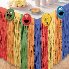 the table is decorated with colorful streamers and sesame street characters, including cookie cookies