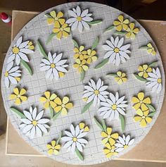 a white and yellow flowered plate sitting on top of a wooden table next to some scissors