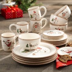 a table topped with plates and cups filled with christmas decorations on top of a wooden table