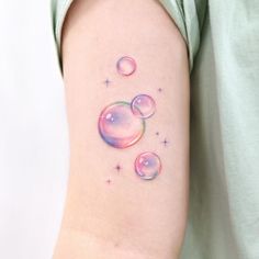 a woman's arm with bubbles and stars on it