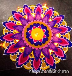 an intricately decorated diya with lit candles