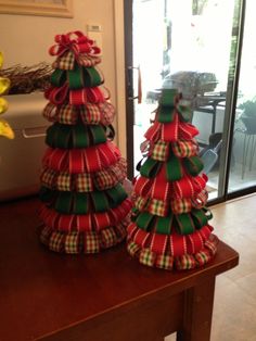 two christmas trees sitting on top of a wooden table