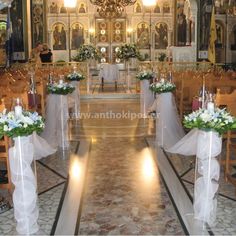 the interior of a church decorated with white flowers and greenery for an outdoor ceremony