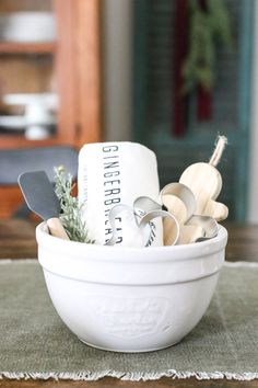 a white bowl filled with kitchen utensils on top of a table