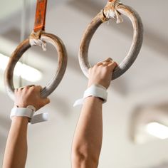 two hands holding rings in the air with one hand and another arm extended up to it