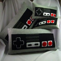 three nintendo controller pillows sitting on top of each other