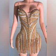 a mannequin wearing a gold and silver dress with chains on it's chest