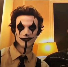 two men with makeup on their faces and one is wearing a creepy clown face mask