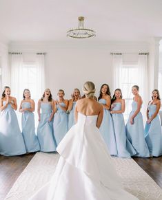 a bride and her bridal party standing in front of each other wearing blue dresses