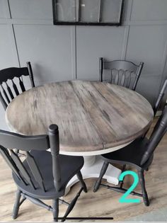 a round table with chairs around it in a dining room or kitchen area that is painted gray and white