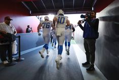 the football players are walking down the tunnel