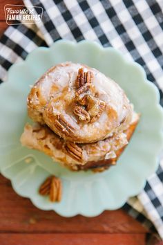 two glazed donuts stacked on top of each other with pecans in the background